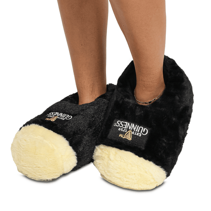 A woman wearing a pair of Guinness Pint Slippers.
