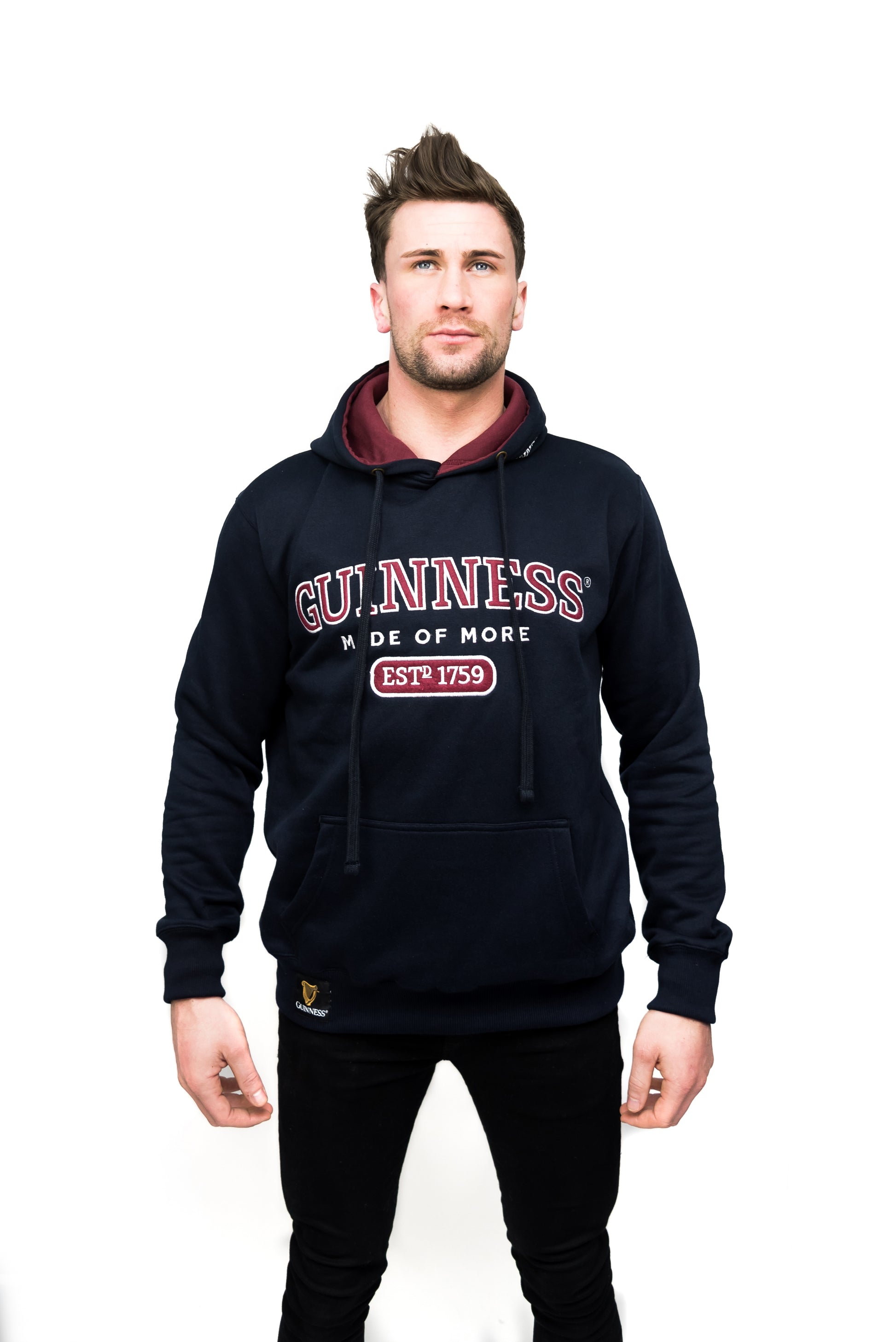 A man wearing a Guinness Signature Navy Hooded Sweatshirt with the Guinness UK logo on it.