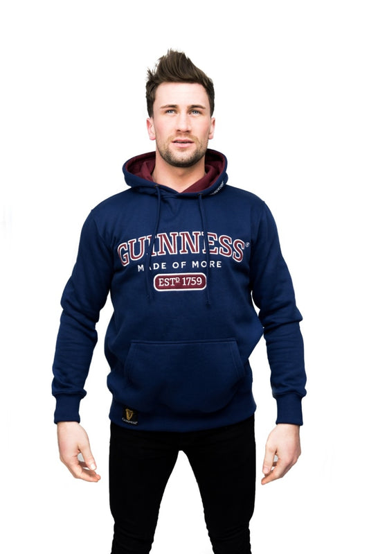 A man wearing a navy Guinness UK hoodie with a hood and a red and white logo.