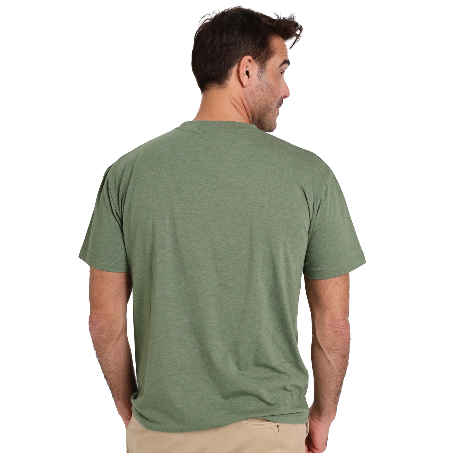 A man with short brown hair, wearing a high-quality Guinness UK poly cotton fiber green T-shirt featuring the Guinness Extra Stout Label and beige pants, stands with his back to the camera, looking to the side.
