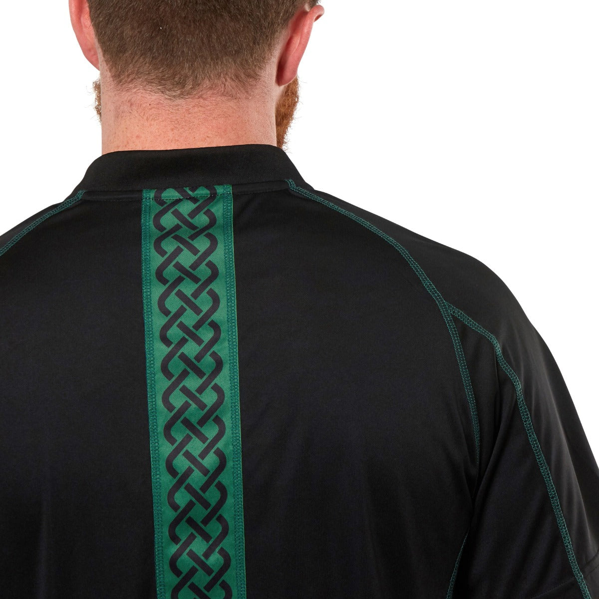 A person wearing the Guinness Black & Green Short Sleeve Rugby Jersey, featuring green stitching and a vertical Celtic pattern down the back.