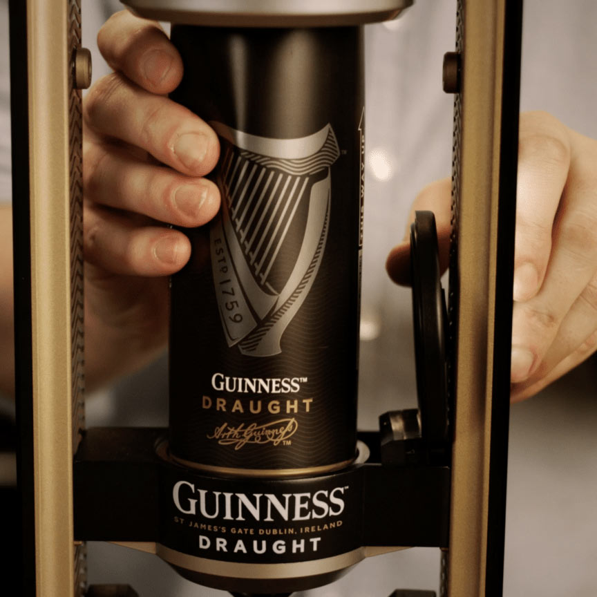 A close-up of a person placing a can of Draught Guinness® into the Guinness MicroDraught machine from Guinness UK for their home bar.