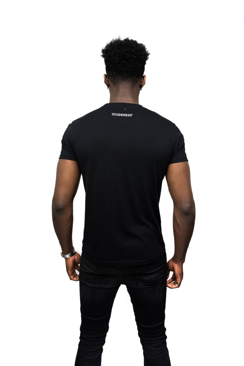 The back of a man wearing a Guinness Black Trademark Label T-Shirt by Guinness UK.