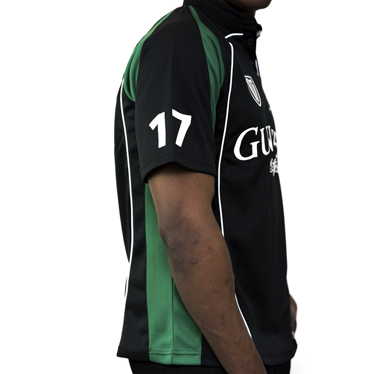 A man wearing a Guinness Black and Green Short sleeve performance Rugby Jersey by Guinness UK.