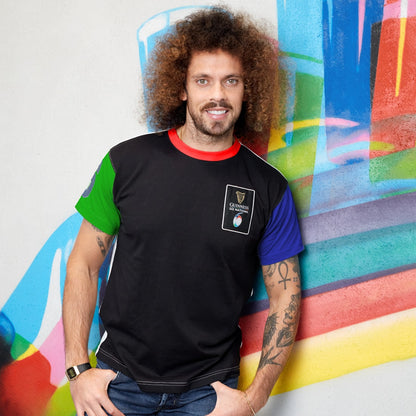 A man wearing a Guinness UK Six Nations Premium Colour Block T-Shirt, with curly hair, standing in front of a colorful wall.