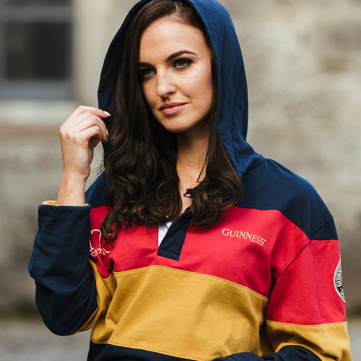 A woman in a Guinness Hooded Rugby Jersey poses for a photo.