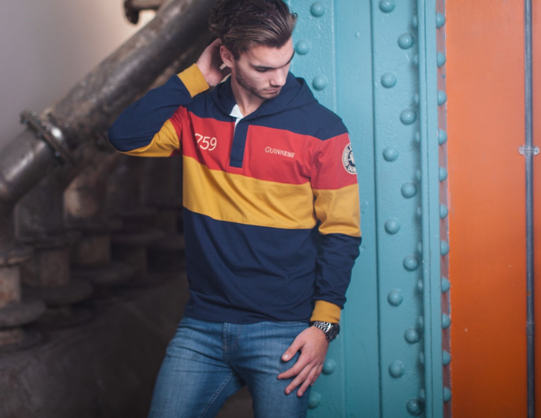 A young man sporting a Guinness Hooded Rugby Jersey in red, blue and yellow stripes.