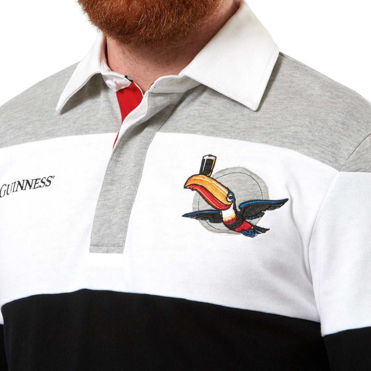A bearded man wearing a Guinness Toucan Rugby Jersey representing Guinness UK branding.