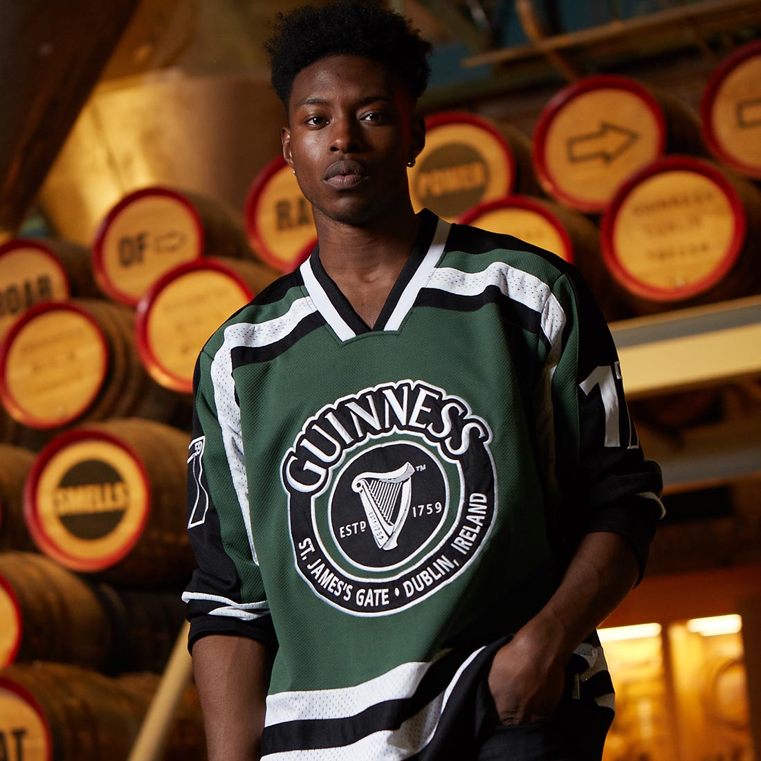 A young man wearing a Guinness UK HARP Hockey Jersey made of polyester.