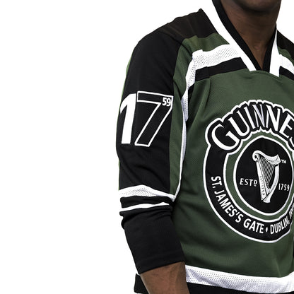 A man wearing a green and black Guinness UK HARP Hockey Jersey made with polyester fabric.
