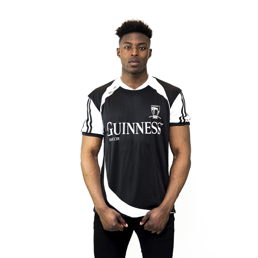 A man wearing a black and white Guinness® soccer jersey featuring the Guinness logo.