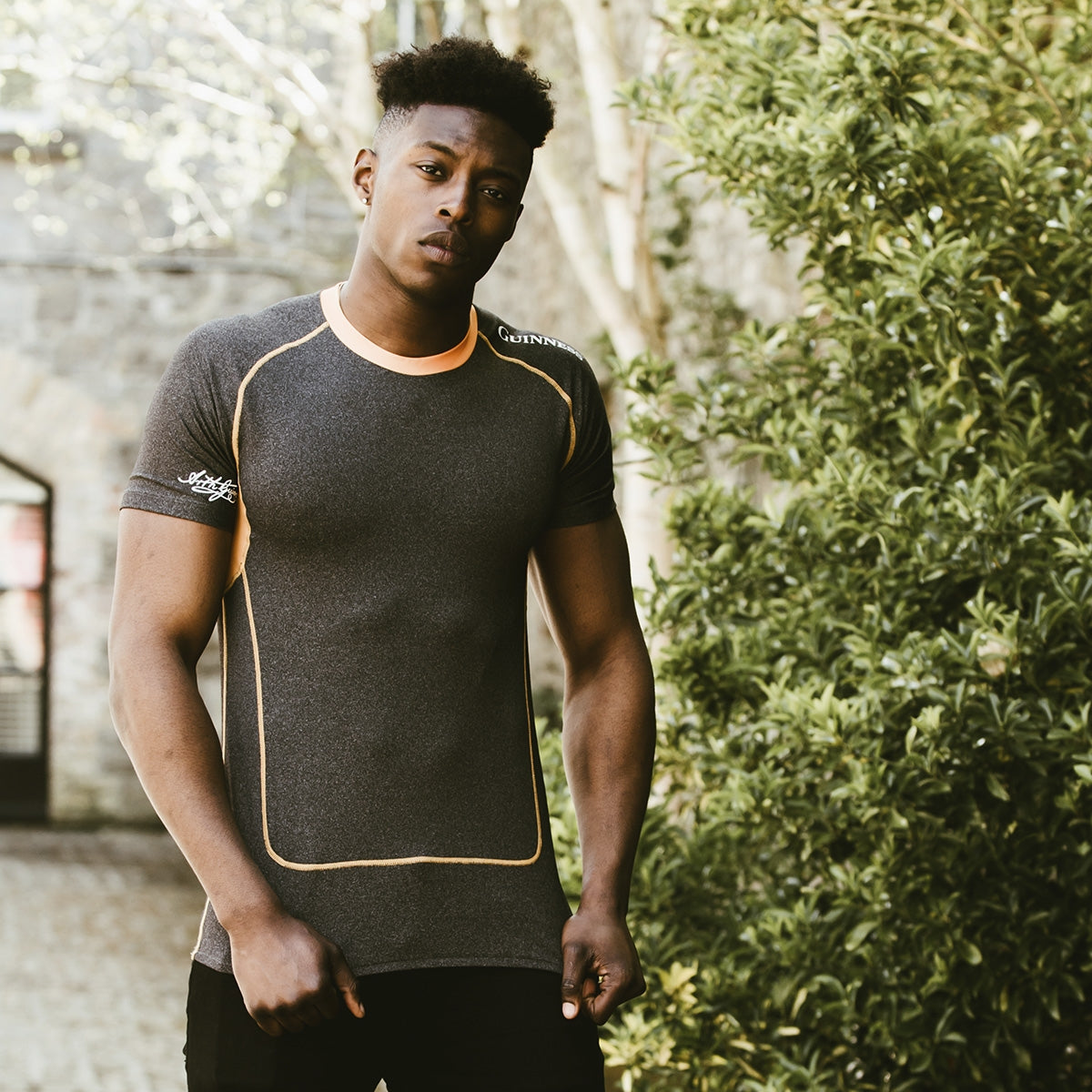 A man wearing a Guinness Compression Top Orange by Guinness UK.