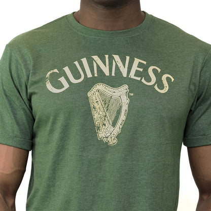 A man wearing a vintage Guinness UK Green Vintage Heathered Harp T-Shirt.