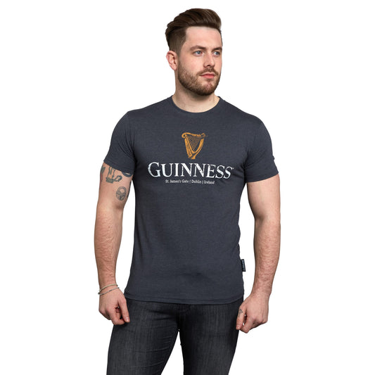 A man wearing a navy Guinness Navy Distressed Harp Logo T-Shirt.