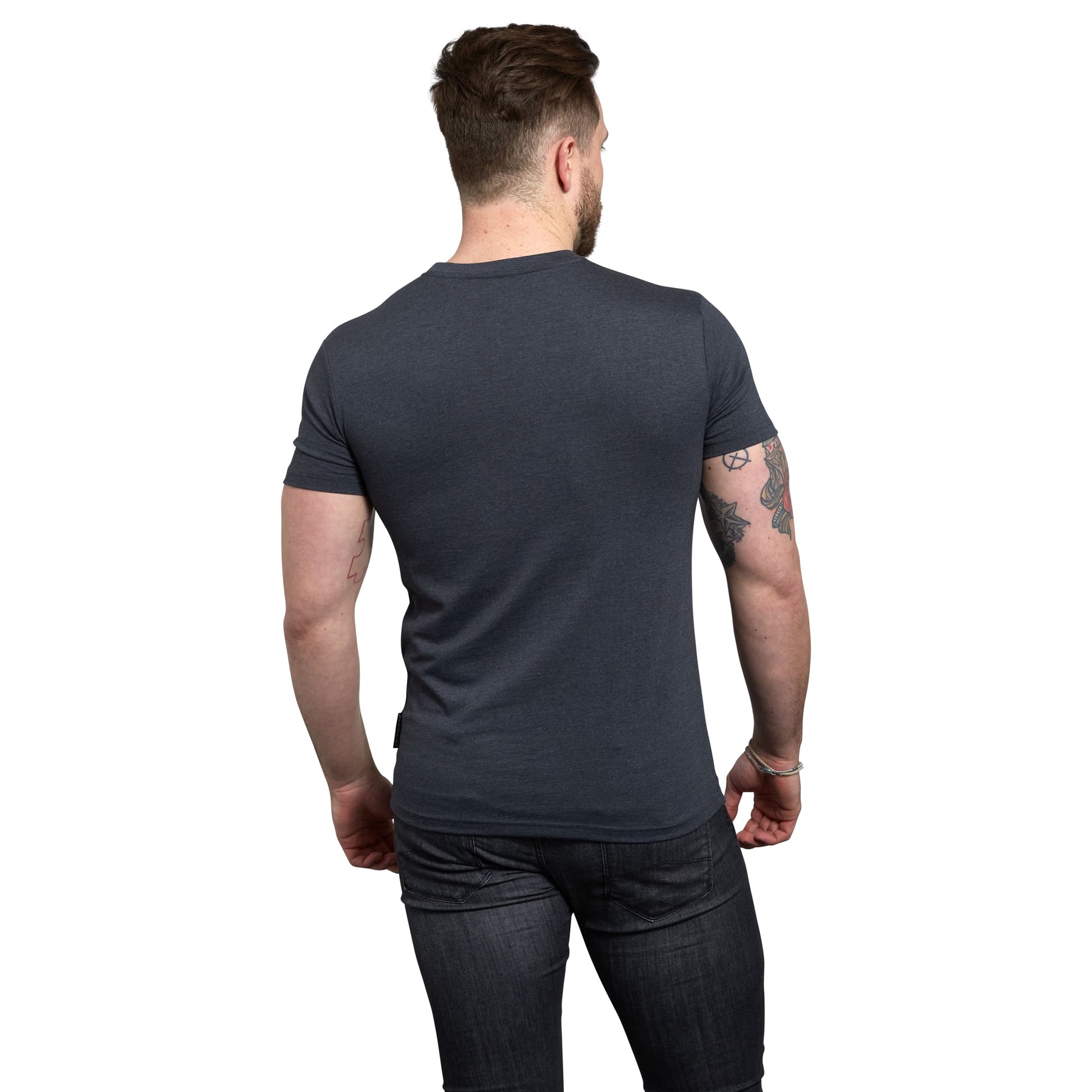 The back of a man wearing Guinness Navy Distressed Harp Logo T-Shirt and navy jeans.