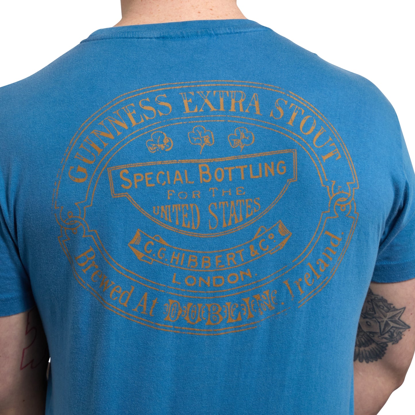 The back of a man wearing a Sky Blue Guinness Harp Premium T-Shirt.