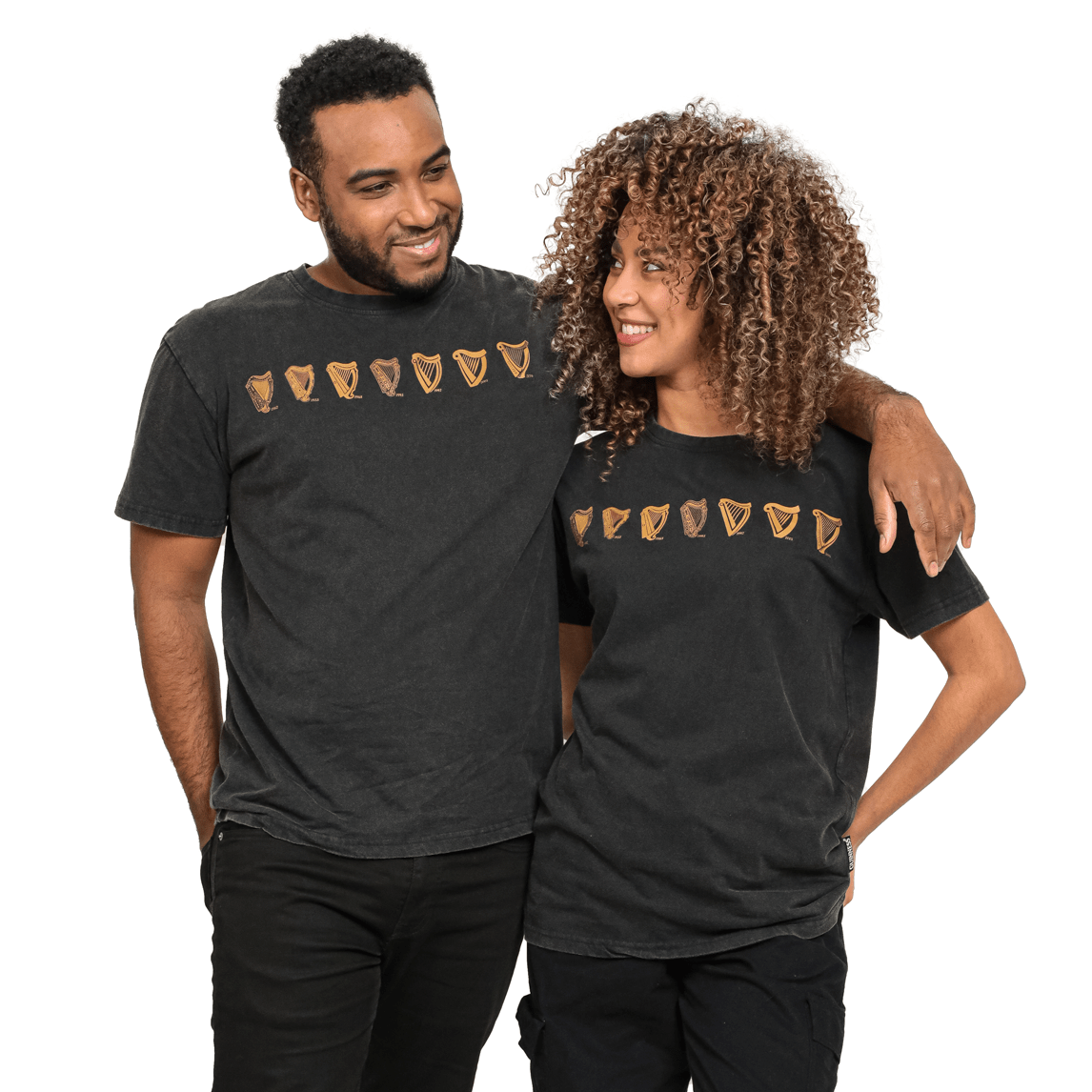 A man and woman standing next to each other wearing a Guinness UK Evolution Harp Tee.