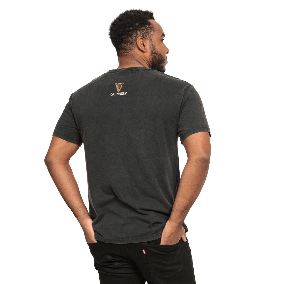 The back of a man wearing a black Guinness UK Evolution Harp Tee made of cotton.