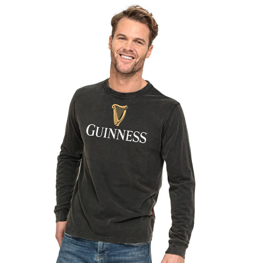 Smiling man wearing a black Guinness® Premium Harp Jumper, posing against a white background.