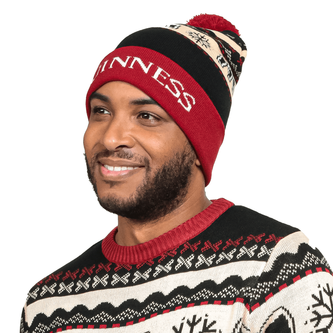 A man wearing an Official Pint Winter Beanie adorned with snowflakes, created by Guinness UK.