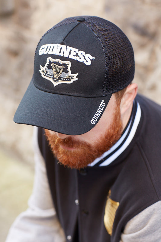 A man with a beard wearing a Guinness UK Black Trucker Baseball Cap.