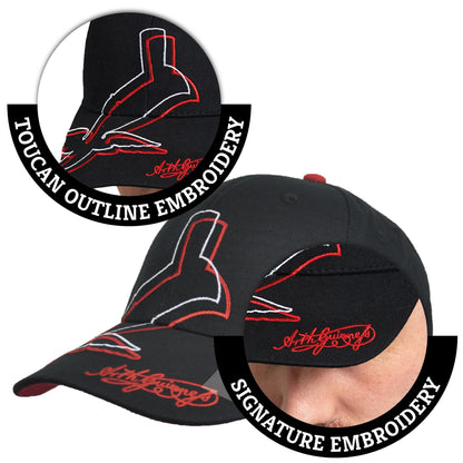 A black Guinness UK baseball cap with a Red Toucan logo on it.