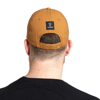 The back view of a man wearing a Guinness Premium Camel & Black with Black Leather Patch Cap by Guinness UK.