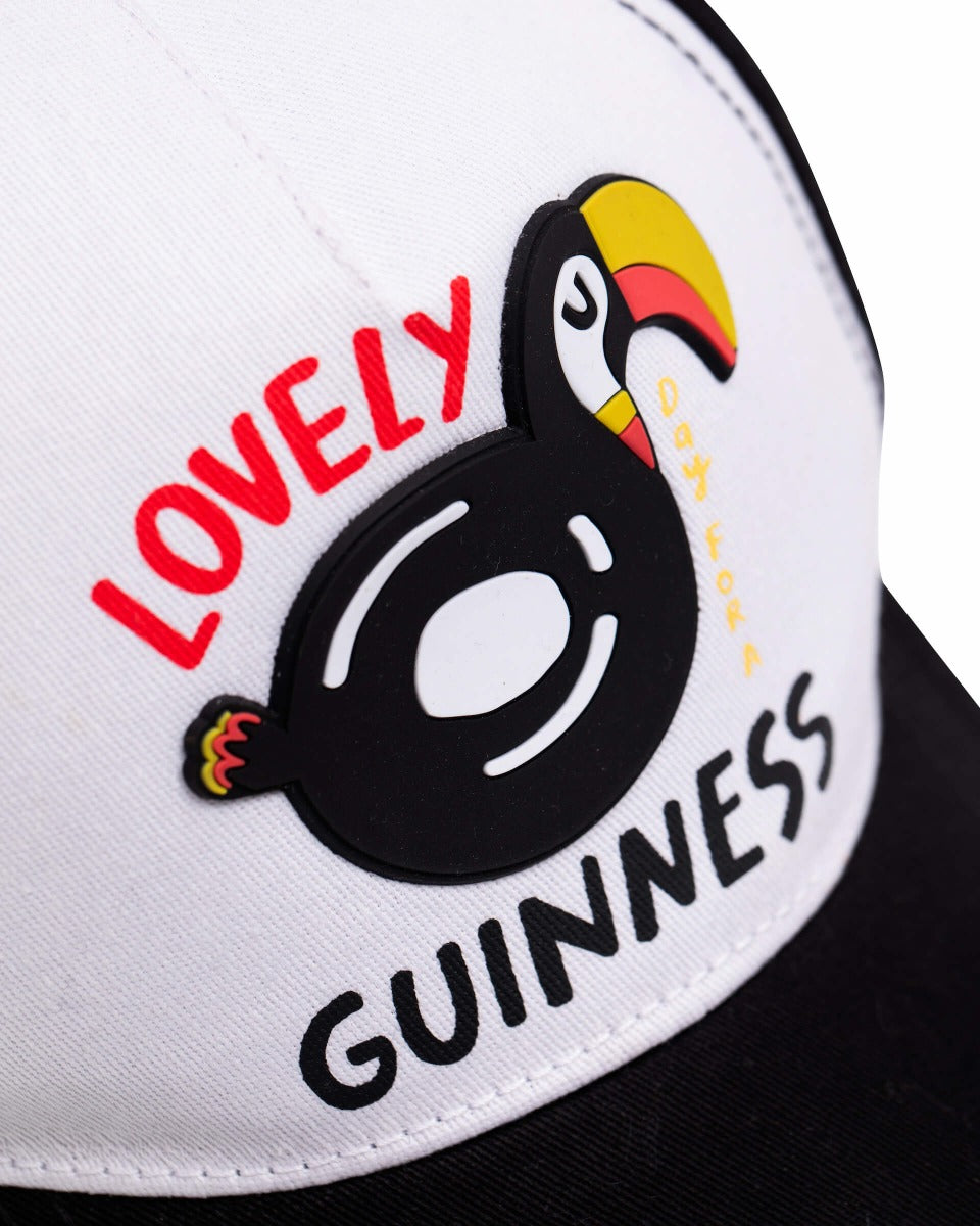 A summer-style Guinness Webstore UK baseball cap with a FATTI BURKE "LOVELY DAY FOR A GUINNESS" toucan on it.