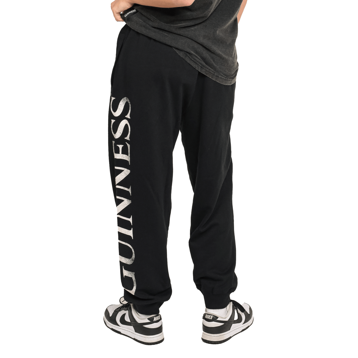 A woman wearing Guinness UK organic cotton black joggers with the word Guinness on them.