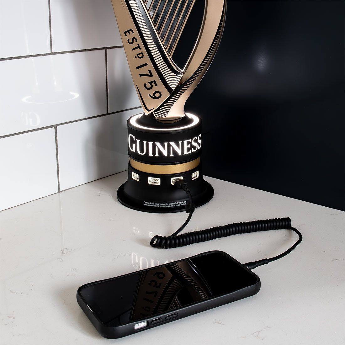 A collectable Guinness harp lamp next to a Guinness UK USB charger.