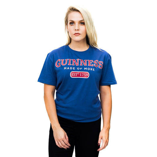 A woman wearing a blue Guinness UK cotton t-shirt, specifically the Guinness Blue Trademark Label T-Shirt.