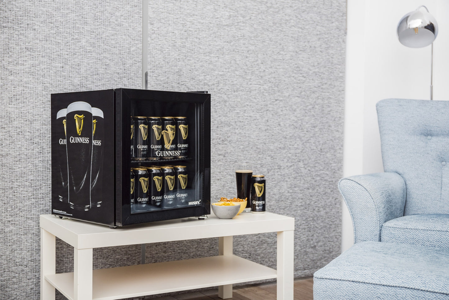 A Guinness Fridge with Guinness beer in it, iconic stout brews chilled, sitting on a table in a living room.