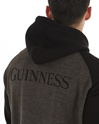 A man sporting a Guinness® Extra Stout Charcoal Label Beer Bottle hoodie with an adjustable drawstring lined hood.