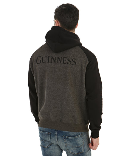 The back of a man wearing a Guinness Extra Stout Charcoal Label Beer Bottle Hoodie, featuring an adjustable drawstring lined hood.
