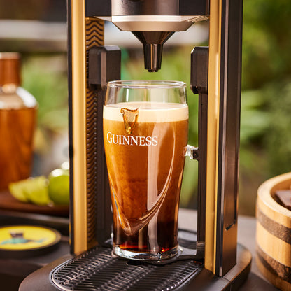A Guinness UK MicroDraught machine is sitting on top of a home bar table.