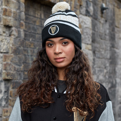 A young woman wearing a warm Guinness Black and White Premium Beanie by Guinness UK.