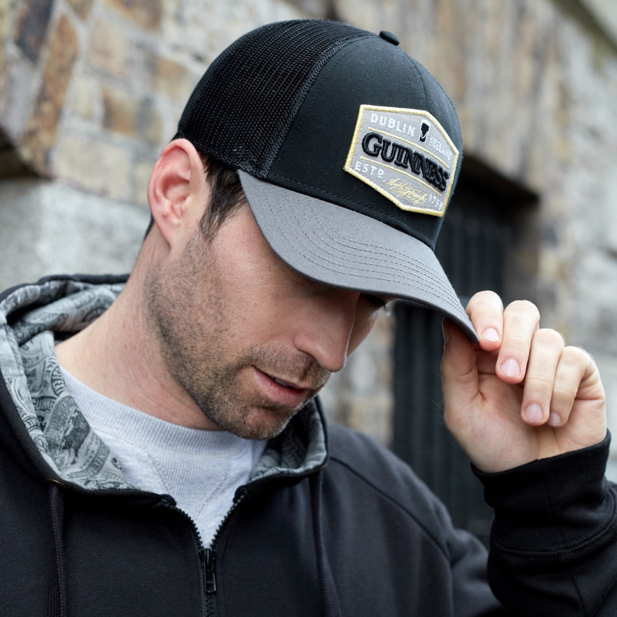 A man wearing a Guinness UK Trucker Premium Grey with Embroidered Patch Cap.