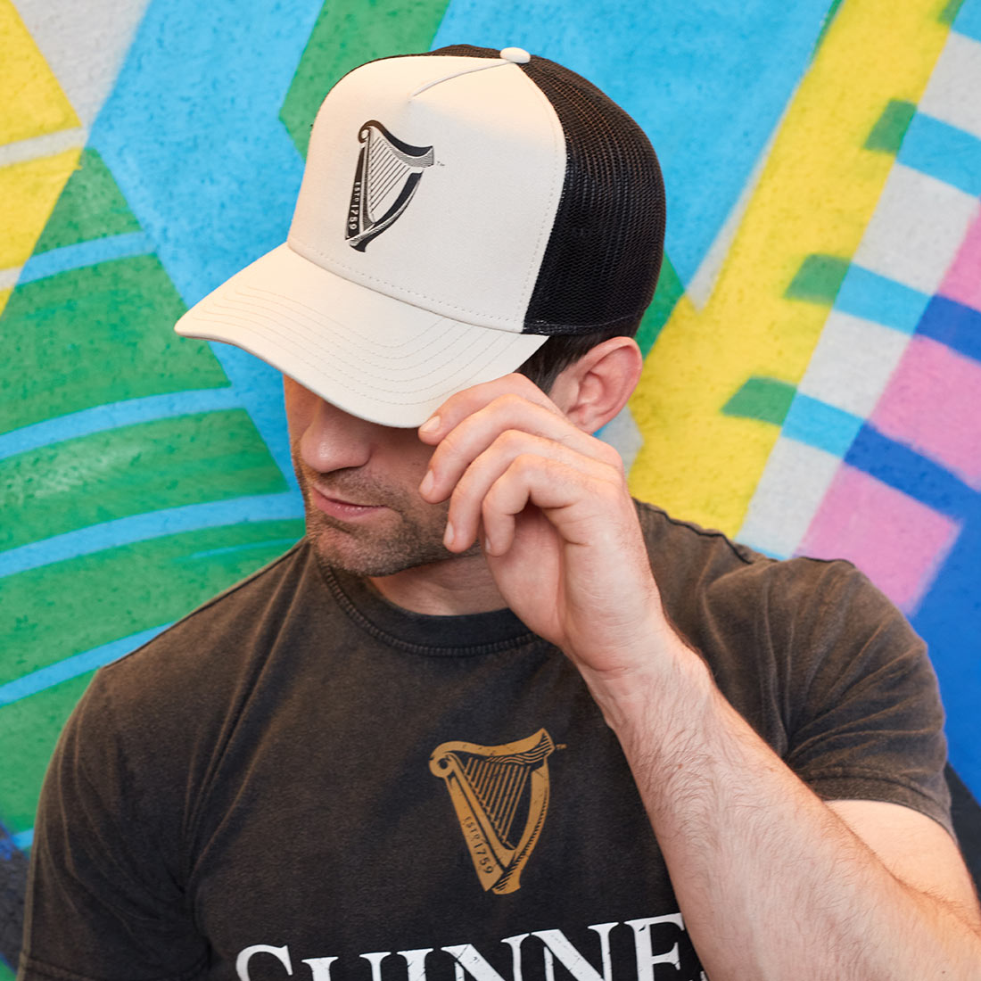 A man sporting a Guinness UK Premium Beige with Black Harp Cap hat.