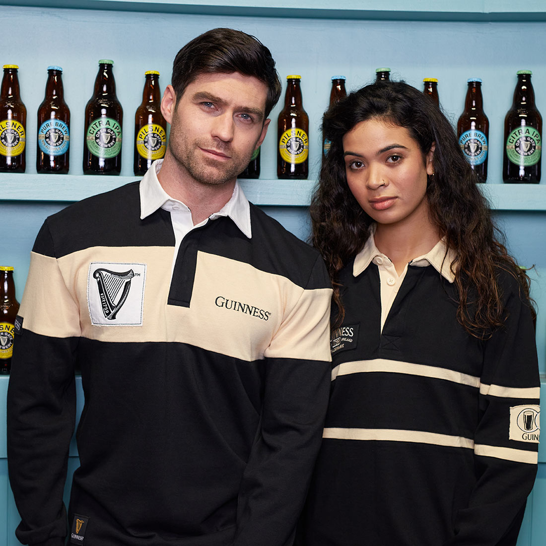 A man and woman sporting comfortable cotton Guinness Traditional Rugby Jerseys.