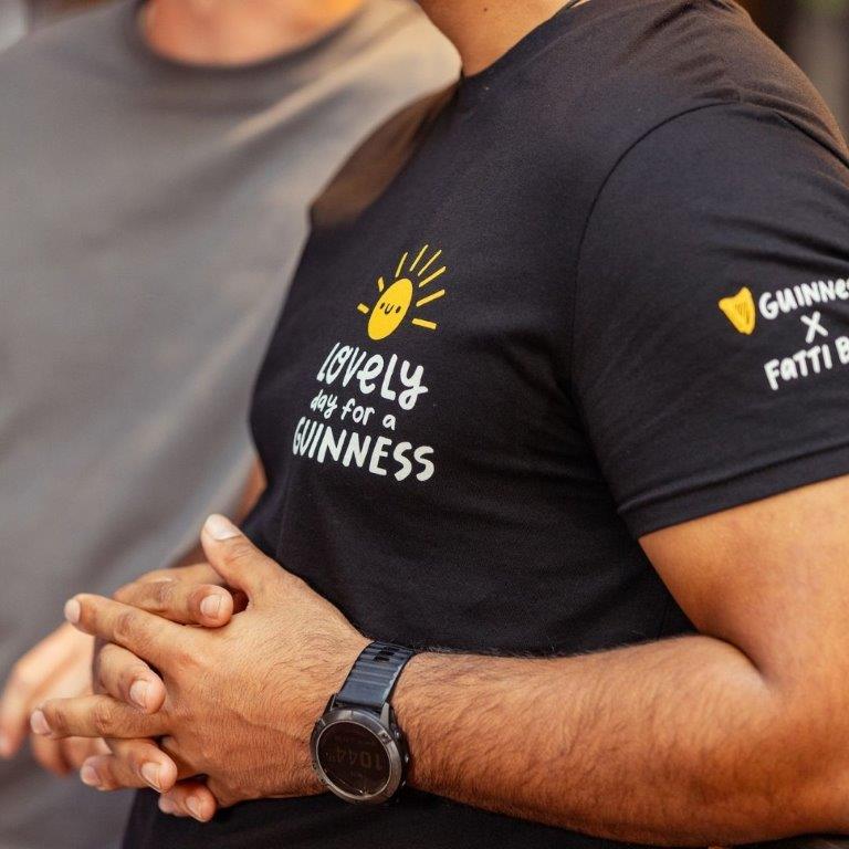 Two men wearing FATTI BURKE "LOVELY DAY FOR A GUINNESS" BLACK T-SHIRTS from the Guinness Webstore UK, showcasing the lovely day for a Guinness during the festival season.