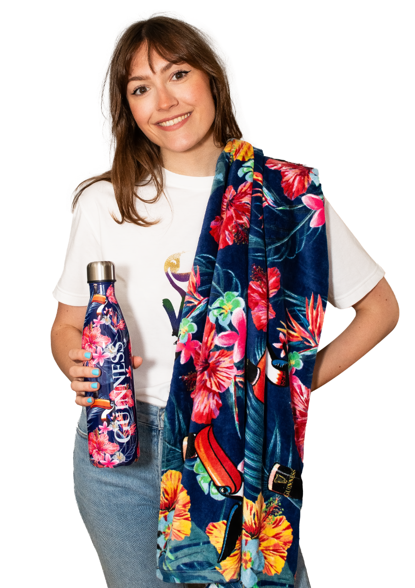 A woman holding a Guinness Toucan Hawaiian Water Bottle and a colorful towel.