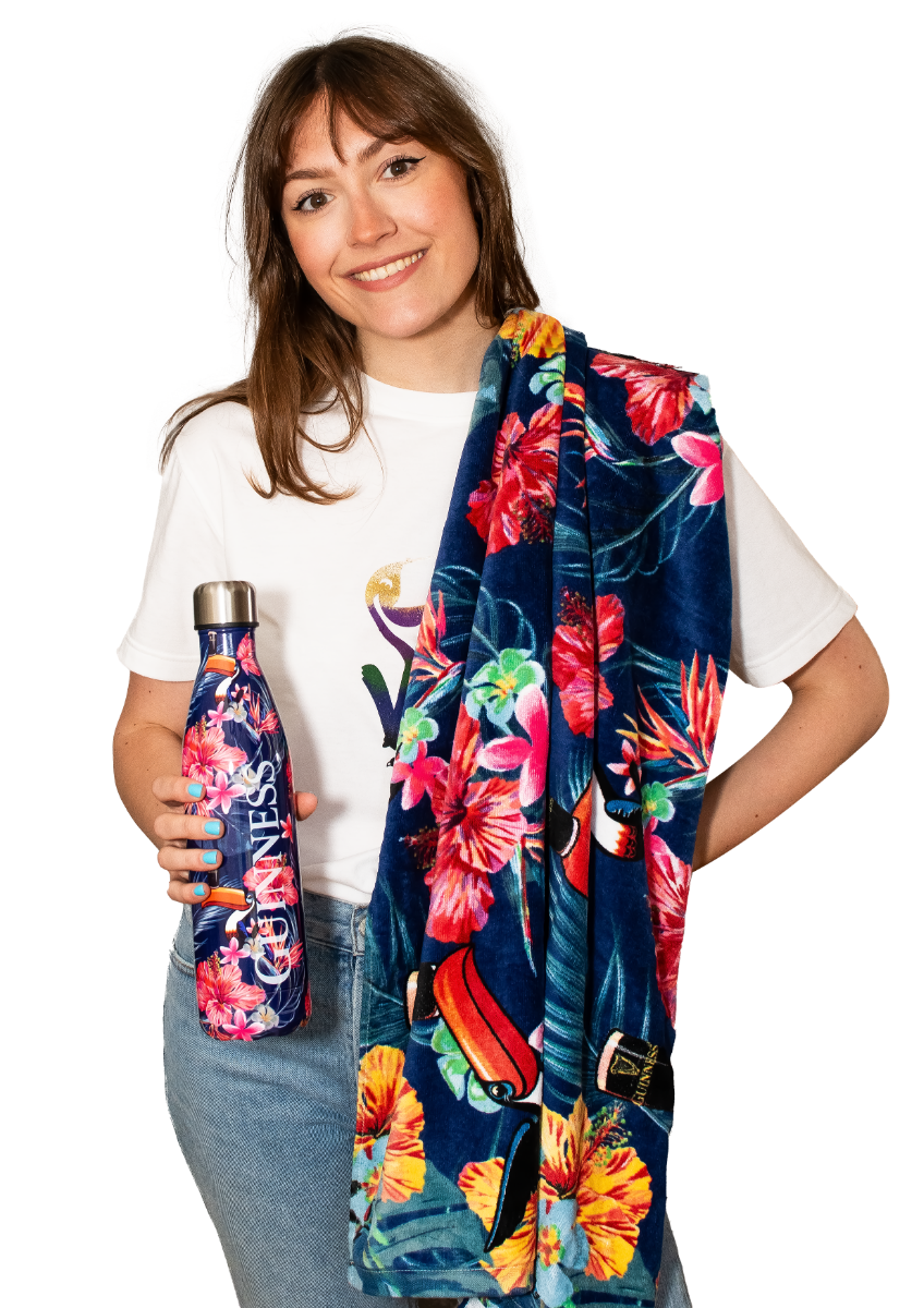 A woman holding a Guinness Toucan Hawaiian Beach Towel by Guinness UK.