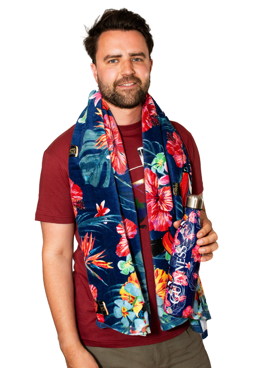 A man wearing a Guinness UK Guinness Toucan Hawaiian print scarf holding a water bottle, enjoying summer lounging.