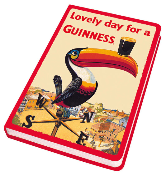 Guinness Webstore UK's Gilroy Toucan Notebook features a classic design with the iconic toucan balancing a glass of beer on its beak, accompanied by the text "Lovely day for a Guinness.