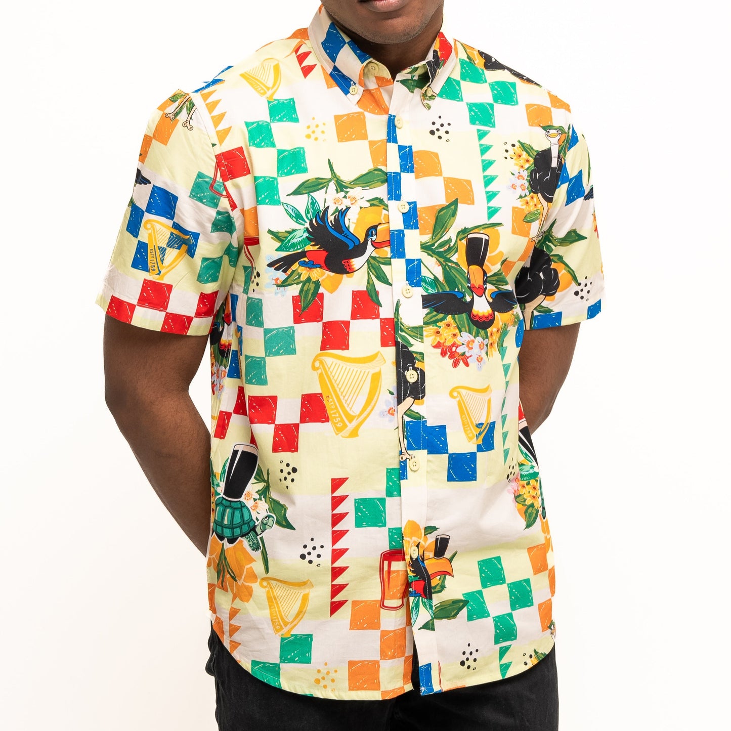 A person wearing the Guinness Toucan Beach Shirt from Guinness Webstore UK, a vibrant Hawaiian-style shirt with geometric and tropical prints, made from breathable woven cotton.