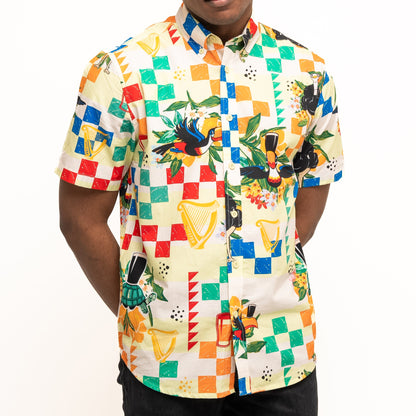 A person wearing the Guinness Toucan Beach Shirt from Guinness Webstore UK, a vibrant Hawaiian-style shirt with geometric and tropical prints, made from breathable woven cotton.