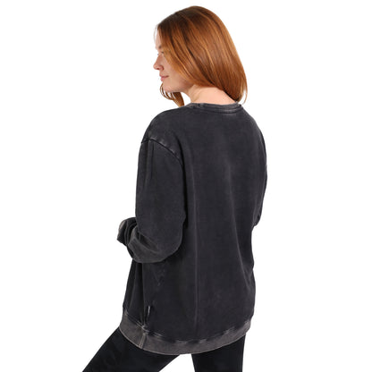A woman with long red hair stands facing away against a white background, wearing the loose-fitting Guinness Metallic Print Trademark Sweatshirt from Guinness Webstore UK, paired with black sustainable cotton pants.