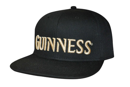 The Guinness UK Flat Brim Baseball Cap features sleek "GUINNESS" gold embroidery on the front and a convenient snapback closure system for a perfect fit.