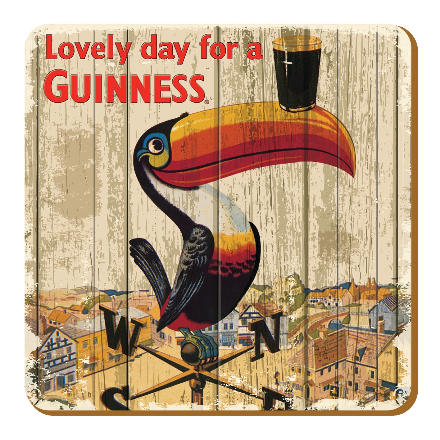 The Guinness UK Nostalgic - Toucan Weathervane Coaster showcases a vintage advertisement with a toucan weathervane balancing a pint on its beak against a cityscape, alongside the text "Lovely day for a Guinness." This nostalgic piece is designed to evoke memories of classic moments at every glance.