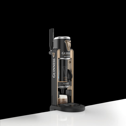 A Guinness UK Guinness MicroDraught beer dispenser against a black background, positioned on a white surface. The dispenser is branded with the Guinness UK logo and has a black, gold, and white color scheme—perfect for any sophisticated home bar setup.